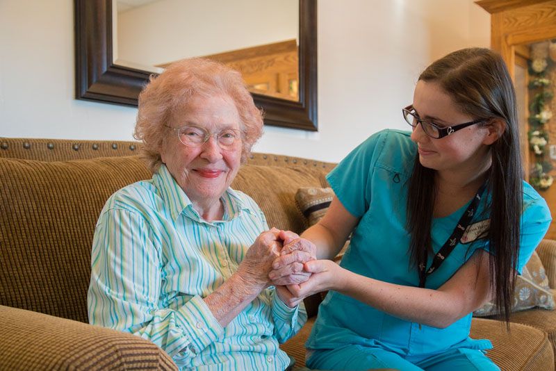 Pavilion caregiver holding hands with senior living resident