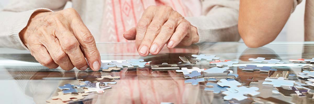 Pavilion caregiver working on a puzzle with a memory care resident